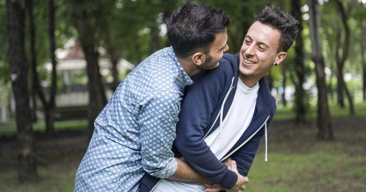  Couple d'hommes homosexuels souriants et complices s'enlaçant