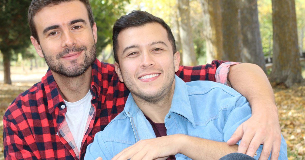 Couple d'hommes gays s'étreignant avec tendresse dans un parc, moment d'intimité amoureuse 
